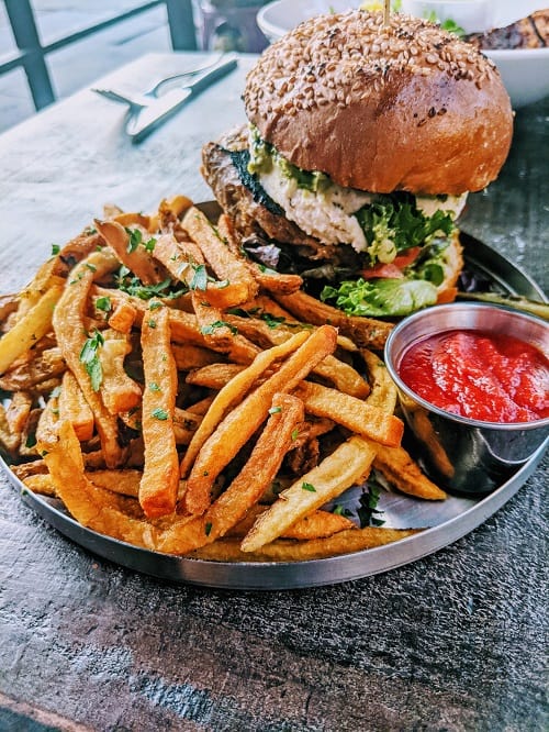 giant burger next to a pile of golden french fries from modern love in brooklyn