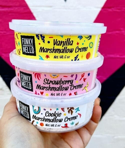 three tubs of vegan marshmallow cream held on top of each other at philadelphia's vegan grocery store
