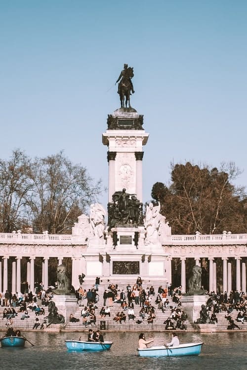 large monument in front of the pond at parque del retiro
