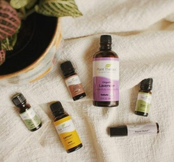 multiple essential oil bottles laying on a white cloth from plant therapy