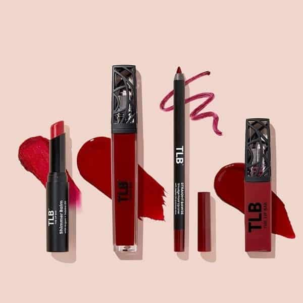 multiple red makeup products from the lip bar on a pink background