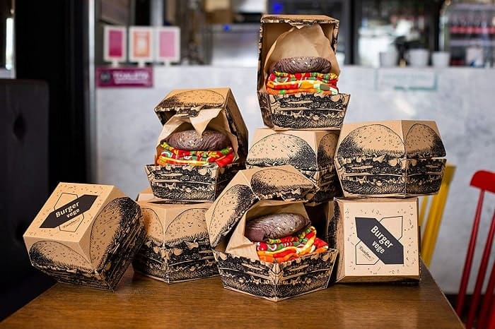 hamburger boxes sitting on a wood table filled with hamburger themed socks