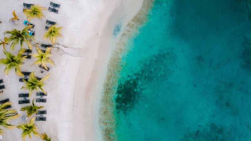 overhead view of white sand beach and turquoise waters in the Caribbean 