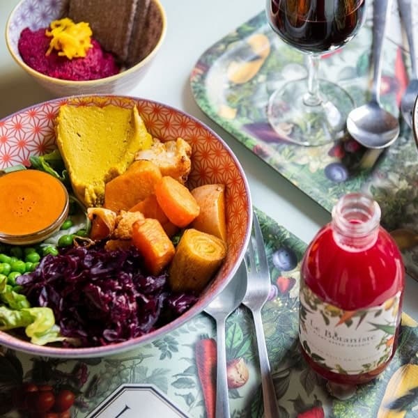 colorful vegan veggie bowl and pink beet juice on a tray at le botaniste in brussels