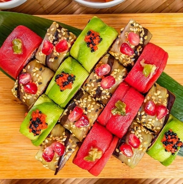 bright pink and green vegan sushi rolls on a wood platter at edamame in warsaw