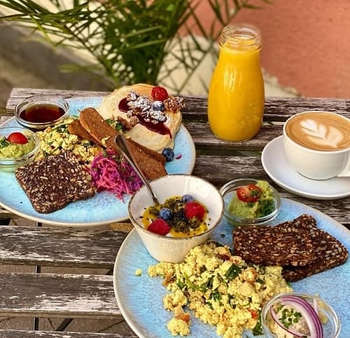 a large vegan breakfast spread with tofu scramble, toast and veggies on a wood table in munich