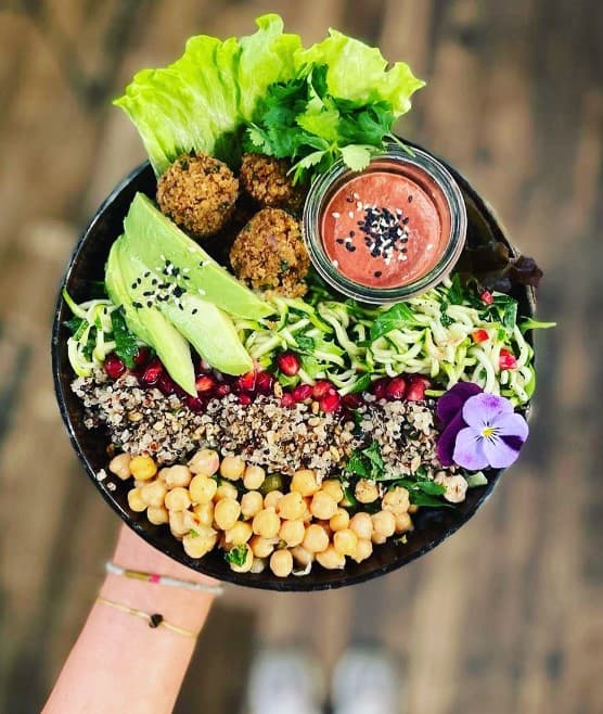 vegan falafel bowl with fresh chickpeas, avocado, and greens at nomad in bruges