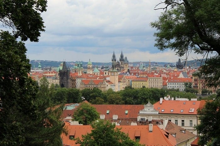 view of the city of prague from a clearing in the trees at petrin park