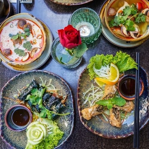 a beautiful display of multiple plates of vegan vietnamese dishes in munich