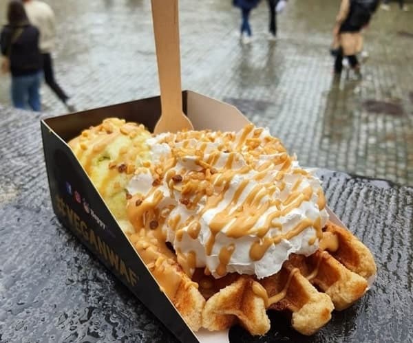 one golden vegan waffle topped with whipped cream and caramel from the vegan waf in brussels