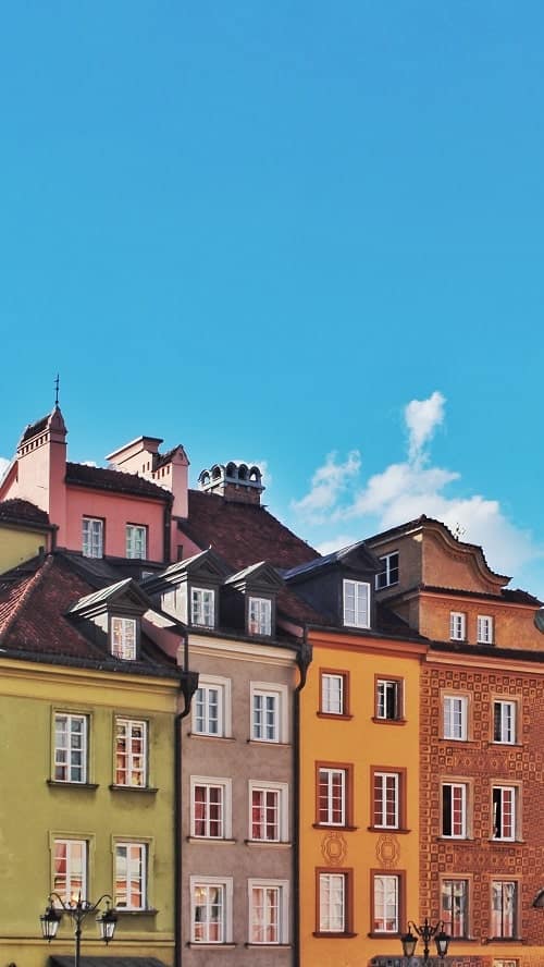 up close shot of colorful buildings in green, yellow, and orange in warsaws old town