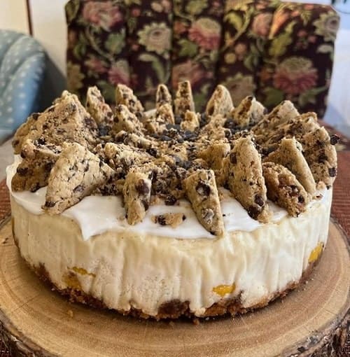 white vegan cheese cake with a cookie crust and topped with chopped chocolate chip cookies in nyc