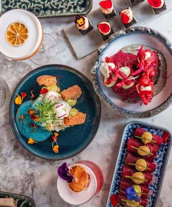a beautiful spread of colorful plant-based dishes like sushi on a marble table at hearth in amsterdam