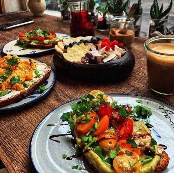 vegan breakfast spread with toast, coffee and an acai bowl at hommage in cologne
