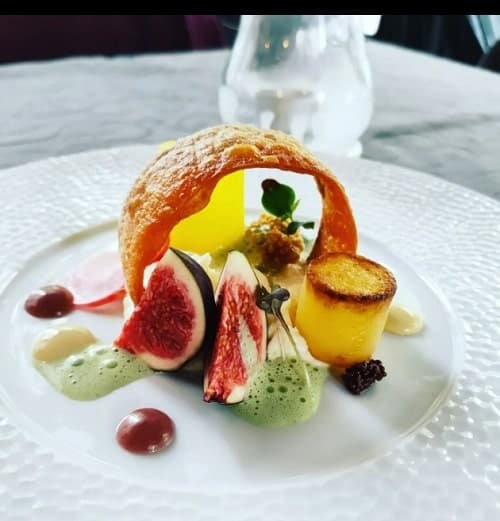 white plate with a vegan puff pastry in the middle surrounded by fresh fruit at lucky leek in berlin