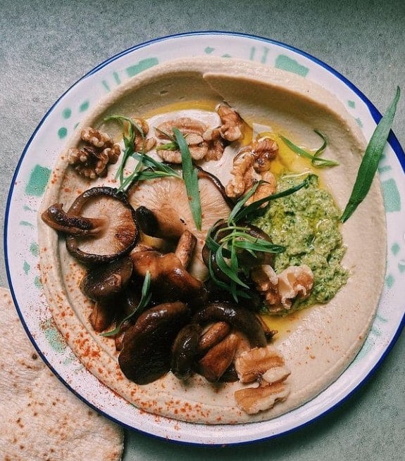 vegan hummus bowl topped with roasted mushrooms at mashery hummus kitchen in cologne