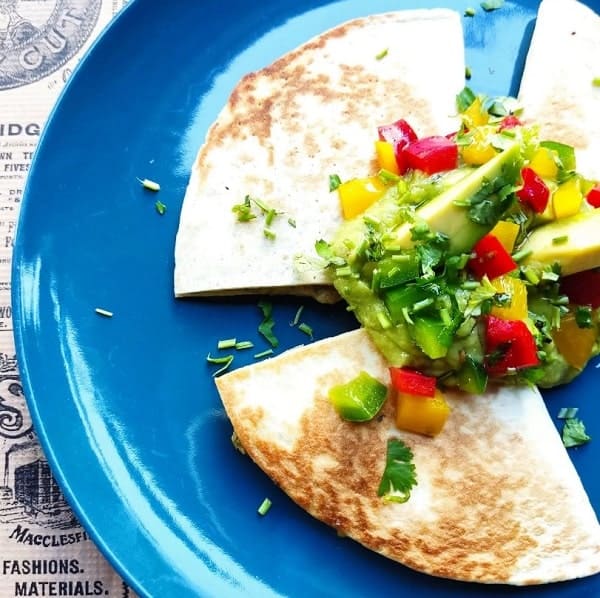 three pieces of a golden vegan quesadilla topped with mango salsa at el enano verde in seville
