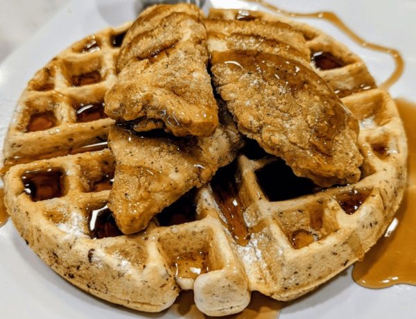 vegan chicken on top of a golden waffle covered in maple syrup from the kitchen in detroit