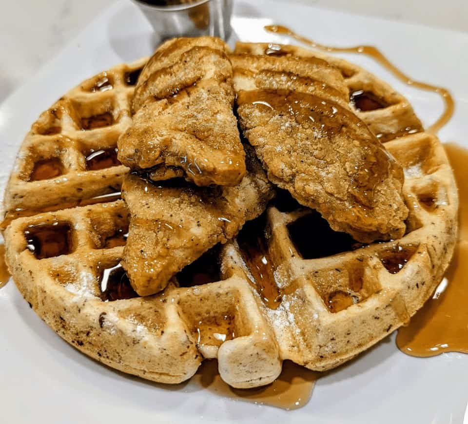 vegan chicken on top of a golden waffle covered in maple syrup from the kitchen in detroit