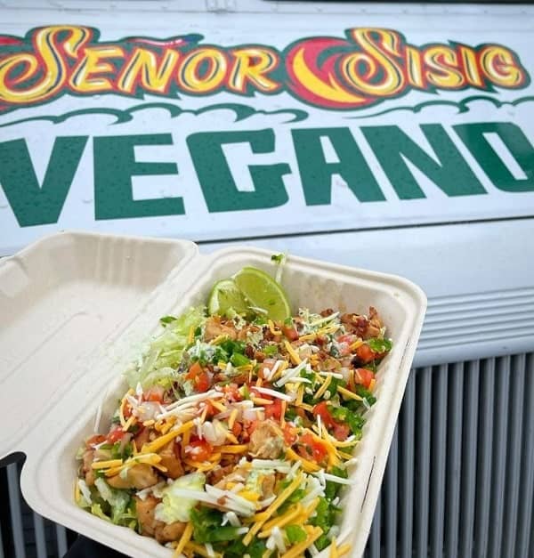 vegan nachos held in front of the senor sisig vegano sign in san Francisco 