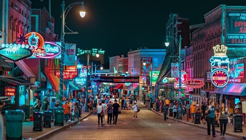 beale street at night with neon lights and crowds of people in memphis