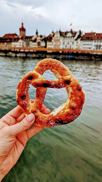 Brezelkonig vegan pretzel on the River Reuss with the Chapel Bridge in Lucerne