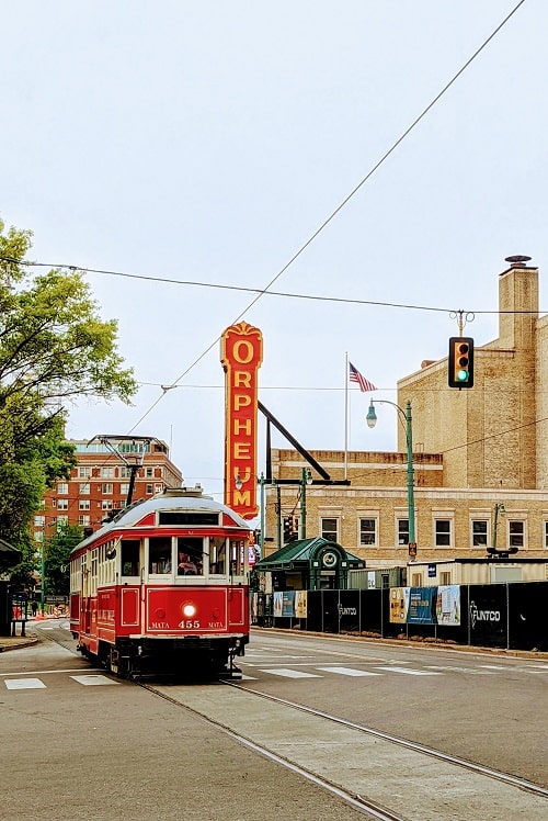 historic red memphis trolly on main street passing orpheum theatre