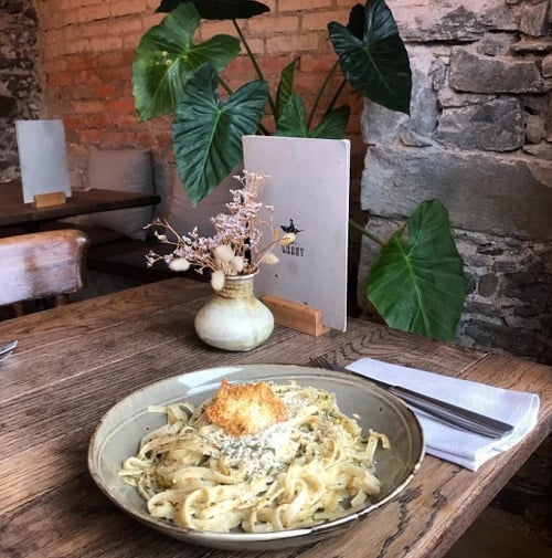 karls kraut vegan cream pasta with fettucine noodles on a wood table