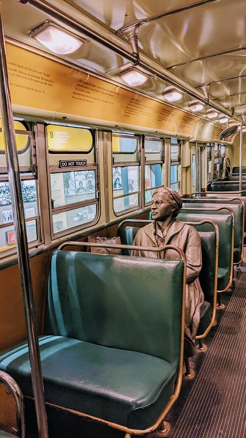 national civil rights museum exhibit with a bronze statue of rosa park sitting on a 1950s bus
