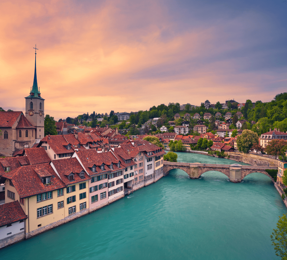 bern skyline at dusk with blue aare river and church in the background