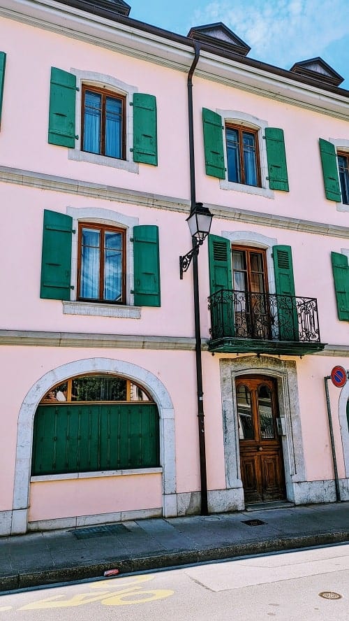 light pink building with green shutters in carouge geneva