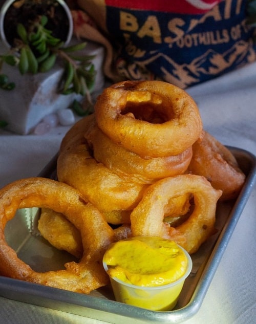 a stack of golden vegan onion rings from freya's diner in st pete