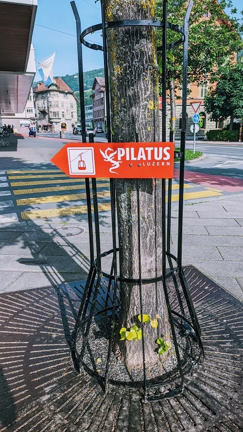 red mount pilatus directional sign on a tree showing the way to the cable car station