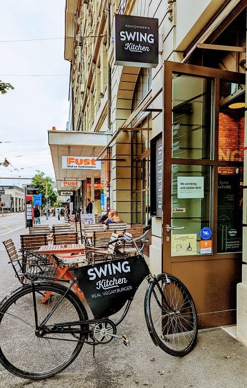 the outside signage with a bike and patio for swing kitchen in bern