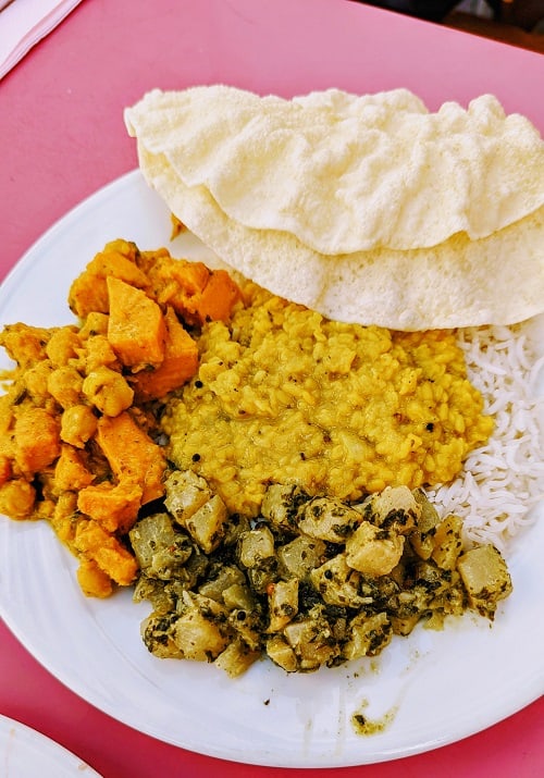 vegan indian food that includes lentil curry. sweet potatoes, herbed potatoes and bread from 3 dosha ayurveda