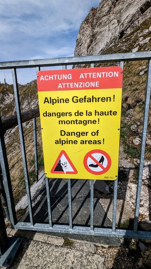 yellow warning sign stating heels are not allowed on mount pilatus trails