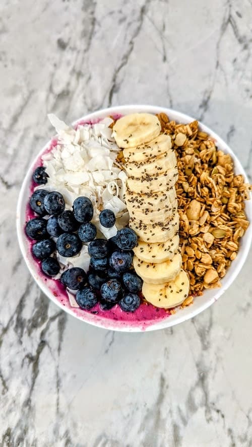 acai smoothie bowl with gluten free granola, bananas, coconut, and blueberries at fruitive