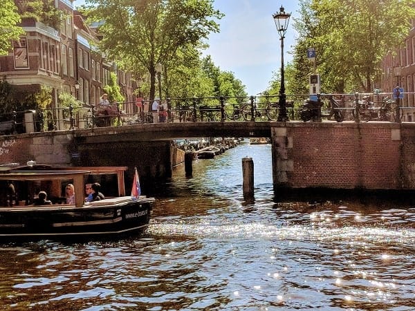 bustling amsterdam canal on a bright and sunny day