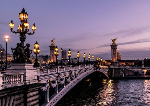 paris bridge over the seine at night with a purple sky in the background