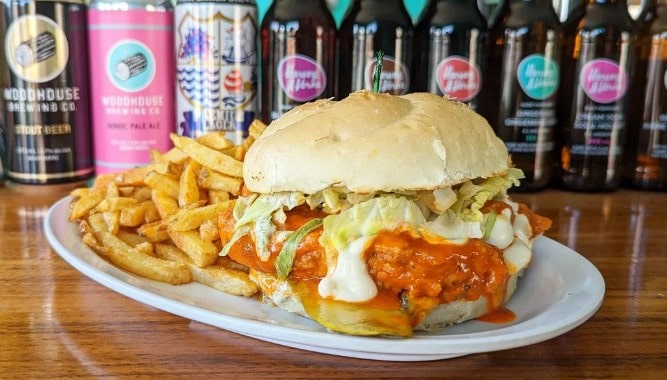 vegan buffalo chicken sandwich on a plate with french fries at hogtown vegan in toronto