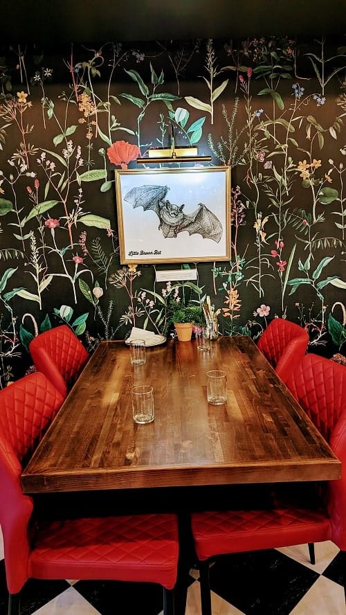 inside of the botanical bar, red velvet chairs and dark floral wallpaper, at dc vegan washington dd