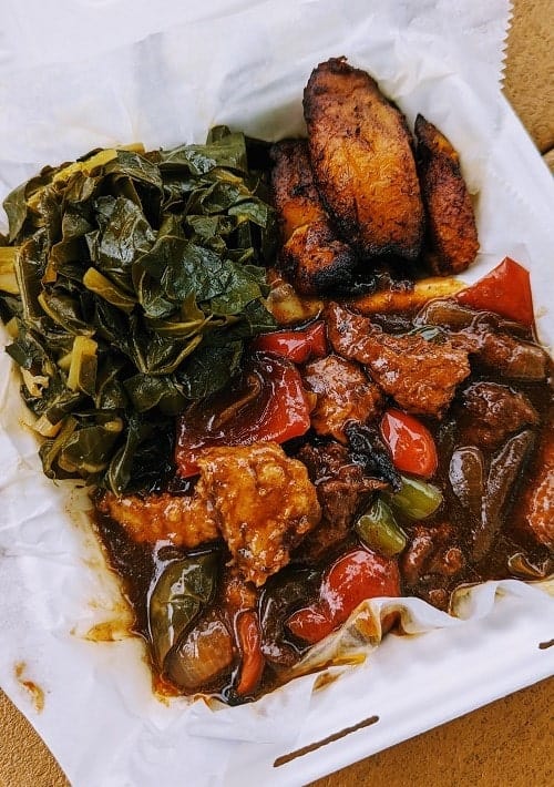 vegan jerk chickn with veggies and plantains and collard greens in a white to go box from Jamaica Way in nashville