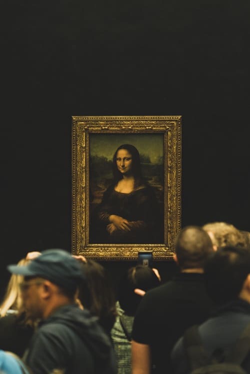the mona lisa painting at the louvre in paris surrounded by people