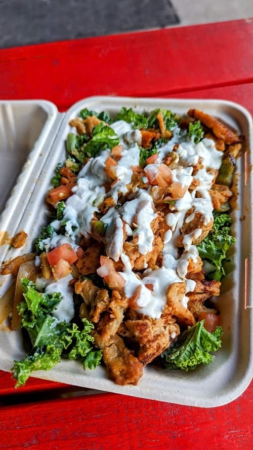 nashville hot chicken caesar salad on a bed of kale and topped with vegan sour cream from be hive in nashville