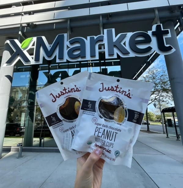 the outside of the plant based xmarket in chicago with a hand holding up two packs of vegan peanut butter cups