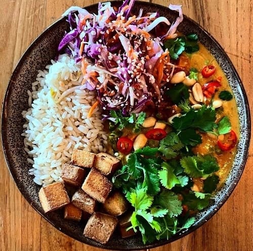loaded veggie bowl with rice, tofu, cabbage, and beans from soil vegan cafe in amsterdam