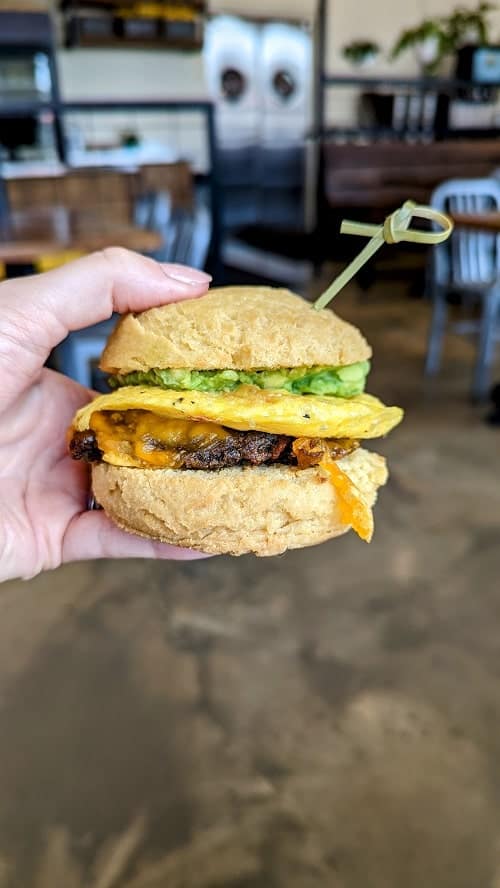 vegan and gluten free breakfast biscuit sandwich with egg, cheese, avocado, and sausage at sunflower bakehouse in nashville
