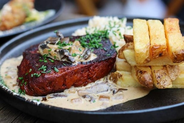 vegan steak with a cream sauce and a pile of thick cut french fries from veginity in dublin