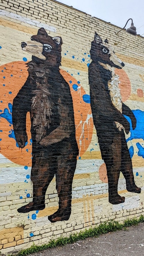 mural of two standing bears on a light yellow building in east nashville