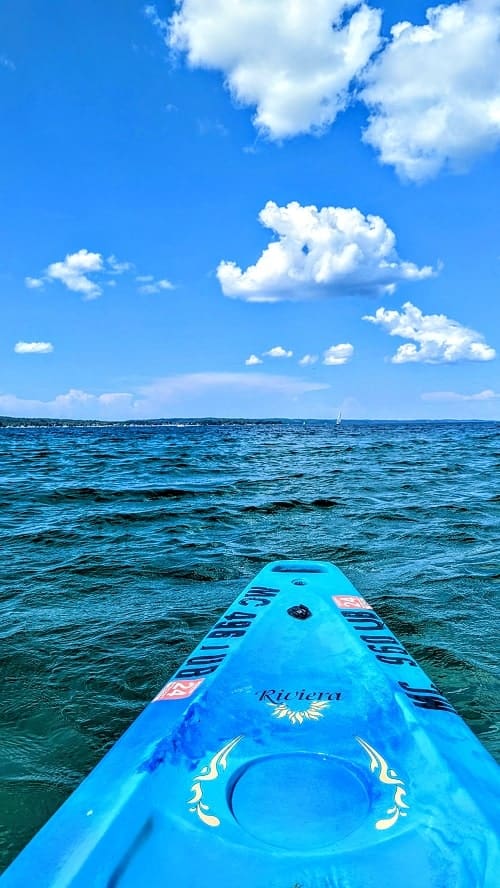 kayaking on grand traverse bay in a blue kayak in traverse city